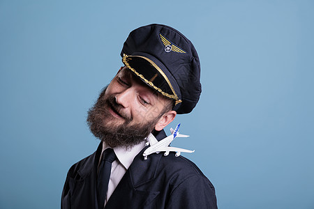 身穿制服的微笑飞行员 肩膀上有飞机模型图片