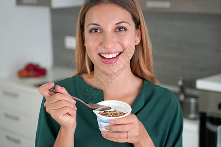 巴西妇女在家里吃白酸奶和加面粉奶制品营养勺子女孩甜点谷物饮食坚果牛奶美食图片