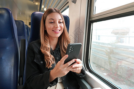 使用公共交通工具 坐在火车上用电话接着电话的年轻商业女青年座位手机旅行运输学生长发游客女士互联网女性图片