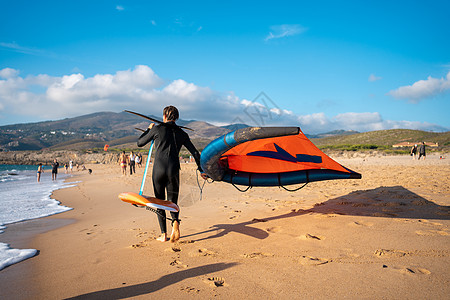 带风筝水土设备在沙滩上行走的人图片