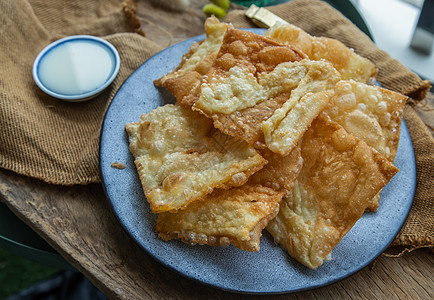 自制的甜脆泰式煎饼在陶瓷板上配有甜奶粉饼子午餐烹饪珠子小吃早餐油炸盘子食物黄油图片