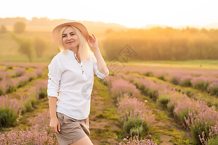 穿着草帽的金发年轻女旅行者 在熏衣草田里 围着紫色花朵牛仔短裤游客火鸡场地蓝色露肩女孩农村薰衣草图片
