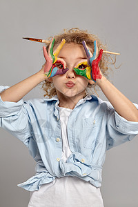 美丽的小女孩 手沾满了油漆的手 在灰色背景上摆着姿势艺术幸福教育绘画童年工艺卷曲发型画家金发女郎图片