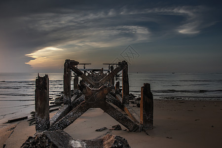 看着破碎的旧结构 在海中美丽的黄昏时期 码头残骸在海上海浪天空邮政建筑蓝色海洋旅游海岸石头钓鱼图片