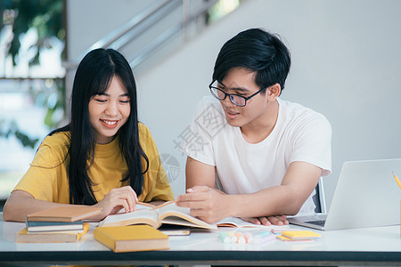 一个亚裔学生正在阅读书本和学习 一起教书小时考试青少年家庭作业男人同学技术图书馆老师导师图片