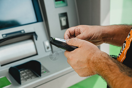 男子 ATM 卡 ATM 插卡 男子拿着钱包将信用卡放入 atm 机键盘取款机信用借方硬币代码银行人士安全塑料图片