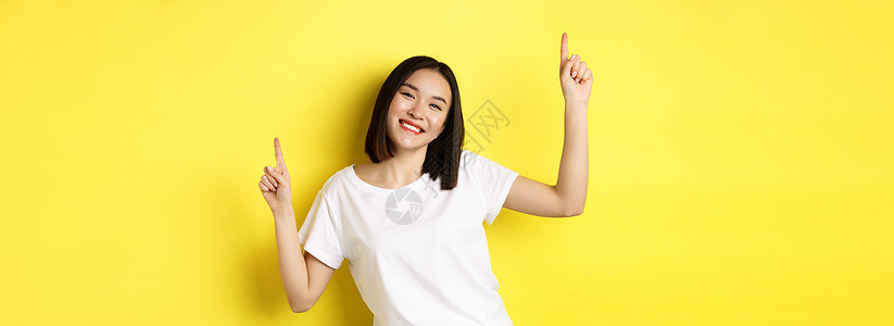 快乐的亚洲女人跳舞和玩乐 穿着白色T恤在黄色背景下穿着白色T恤发型学生情感商业广告女孩手势青少年理发促销背景图片
