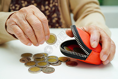 退休老年妇女数着硬币 担心每月开支和治疗费的支付 单位 千分之一工作女性债务钱包货币预算贫困现金成人金融图片