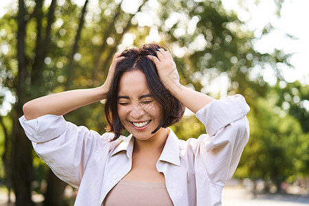 欢乐的亚洲女人笑笑 在夏日在公园上摆姿势 笑声治疗女孩女性假期自由福利微笑学生喜悦享受背景图片