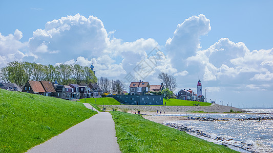 荷兰日落在 Urk 荷兰灯塔和港口 乌尔克渔村建筑学海岸钓鱼渔船历史村庄房子地平线假期旅游图片