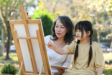 可爱的小女孩和祖母 在夏日公园画画 在户外一起度周末休闲假快乐拥抱享受女性两个人公共公园幸福祖父母奶奶孙子图片