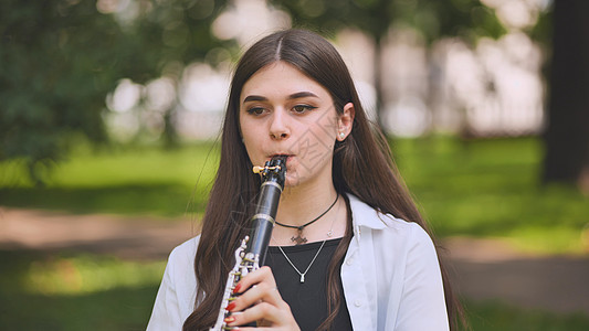 一个女孩在公园里弹单簧管图片