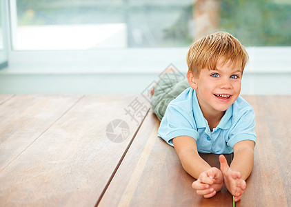 在家里玩得开心 一个可爱的小男孩在家的餐桌上玩耍房子幸福男生说谎青年乐趣地面孩子孩子们男性图片