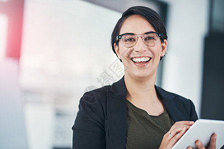感觉积极并取得进步 一位成功的女商务人士在办公室使用她的平板电脑的画像图片