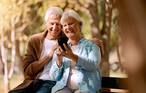 放松 快乐 并与公园里的老夫妇通电话 进行视频通话 社交媒体和交流 微笑 健康和互联网 男人和女人坐在大自然的长凳上退休 5g 图片