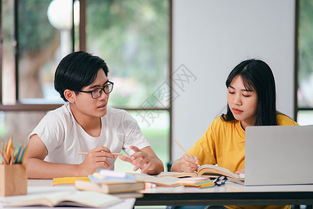 一个亚裔学生正在阅读书本和学习 一起教书导师考试瞳孔团队课堂朋友们电脑大学智力学校图片