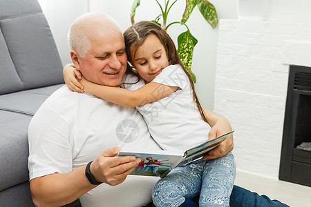 快乐的小女孩和爷爷 在家看照片书的小姑娘刘海白发孙女祖父边缘男性孙辈闲暇写真集教育图片