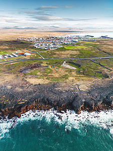 冰岛小城镇的垂直照片 海浪在前面岸边压碎了图片