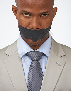 商业界不喜欢吹口哨者 一个非洲美国商务人士的摄影棚肖像 他的嘴被胶带覆盖着图片