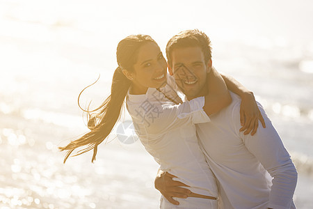 分享慈爱的凝视和温暖的拥抱 在海滩上相亲相爱的年轻情侣女朋友夫妻男人女性女孩男性旅行微笑成人女士图片