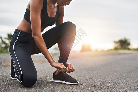 一个运动的女性在户外锻炼时绑着鞋带的特拍镜头 近距离拍摄到最后图片