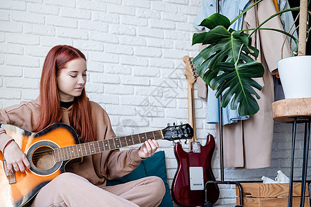 在家里弹吉他的年轻女子女孩艺术家吉他手乐趣爱好乐器学习快乐头发音乐图片