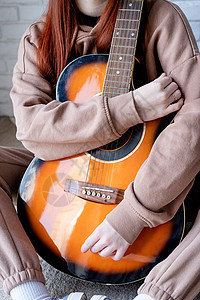 在家里弹吉他的年轻女子爱好成人头发吉他手艺术家女士幸福乐趣音乐女性图片