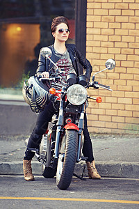 她让那辆摩托车看起来不错 外面有个年轻又时髦的女摩托车骑手图片