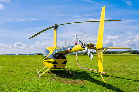 现代小型轻型直升机在草地上对准蓝天的蓝色天空图片