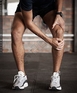 膝盖受伤 疼痛和健康 一名运动员在健身房锻炼时握住他的关节 一名男运动员在健身俱乐部训练时受伤的解剖学 事故和锻炼图片