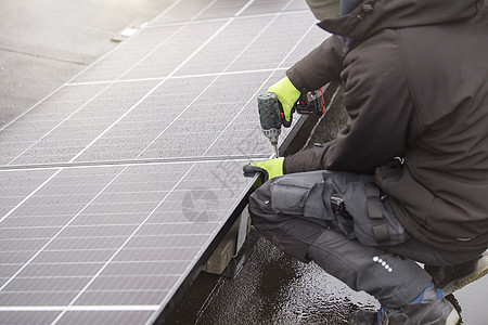 再生能源 绿色能源概念 安装太阳能电池板的过程 师傅拧紧太阳能电池板模块的安装工人蓝色建筑光伏房子细胞建造技术螺丝刀技术员图片