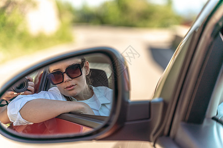 一辆新车里一位美丽的女人的肖像 在后视镜中看着一副后视镜图片