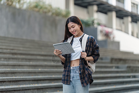 有朋友的美丽的年轻亚裔女大学生在户外 在大学校园工作的大学生背包青少年休闲装男性快乐图书馆笔记本学习学校电脑图片