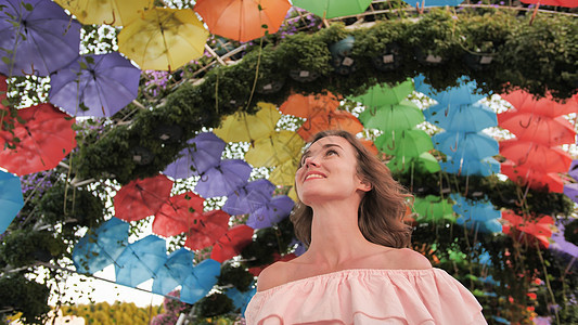 美丽的女孩 背景 多色雨伞 在城市公园的园子里 笑声晴天高架橙子阳伞黄色天空绿色彩虹庇护所天气图片