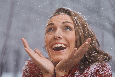 爱着第一次降雪 一个在雪中户外欢乐的女人图片
