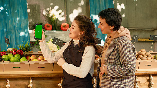 两名女性在智能手机上观看绿屏显示图片