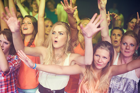女性在音乐节 现场乐队表演和夜总会 音乐会和迪斯科舞厅的技术狂欢派对上举起手来跳舞 舞池中的朋友 人群和观众在表演 自由或能量活图片