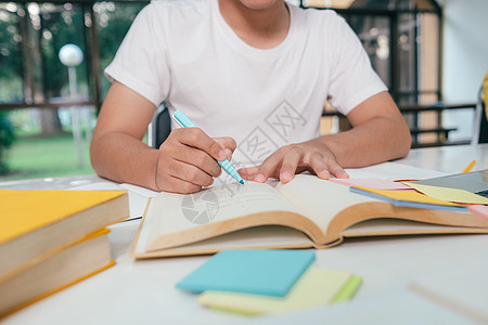 近距离的年轻的亚洲男学生正准备读一本大学考试的书 (笑声)图片