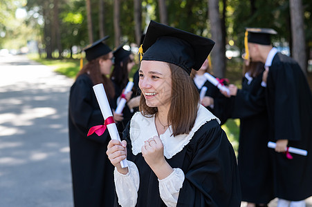 一群在户外穿毕业礼服的快乐学生 年轻女孩很乐于获得文凭教育校园研究生中学幸福长袍同学女性证书女孩们图片