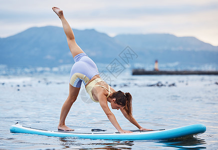 女人 冲浪板或海洋或海上的水上瑜伽放松锻炼 训练或锻炼以实现核心平衡 健康或健康 自然健身或身体普拉提中桨板上的禅宗 平静或和平图片