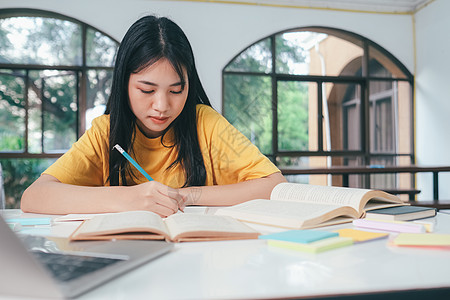 年轻的亚洲女学生正准备读一本大学考试的书 笑声教科书沉思瞳孔学校学院演讲老师教程导师自学背景图片