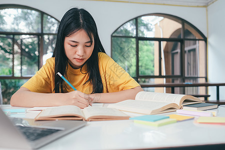 年轻的亚洲女学生正准备读一本大学考试的书 笑声教科书沉思瞳孔学校学院演讲老师教程导师自学图片