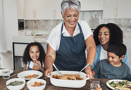 祖母 家庭住宅和孩子们在餐桌旁享用美食 午餐或充满爱 关怀和幸福的庆祝活动 黑人 老年妇女和儿童共进晚餐 聚会 并乐于在厨房里结图片