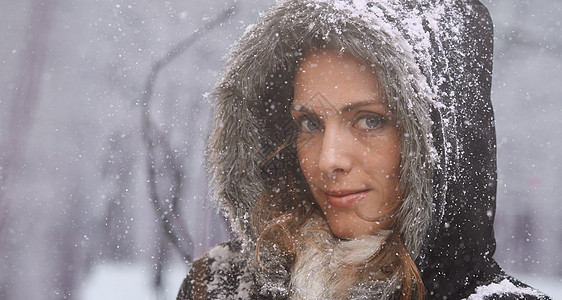 爱第一场雪 一个迷人的女人 在雪中享受着外表的乐趣微笑夹克裁剪下雪天气黑发幸福化妆品衣服季节图片
