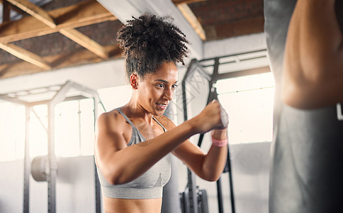 健身房运动健身 黑人女性和拳击 用于在健身房进行力量或耐力训练 锻炼或健康锻炼 体育活动中的非裔美国女拳击手击打出气筒自卫背景