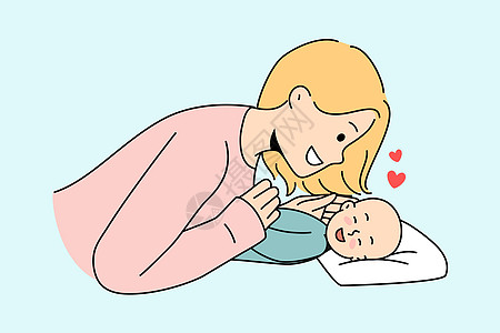 微笑的母亲与新生儿玩耍图片