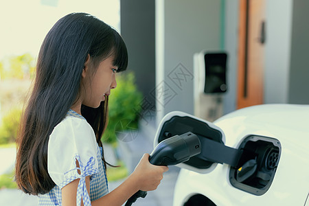 女孩持有EV插头 展示了进步型生活方式的可持续动力源机动性充电器环境杂交种活力力量收费燃料车辆运输图片