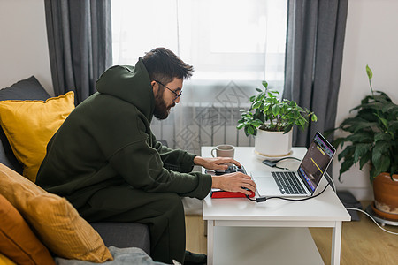 音乐制作人或编曲人使用笔记本电脑和 midi 键盘和其他音频设备在家庭工作室创作音乐 击败制作和安排音频内容和创作歌曲概念图片