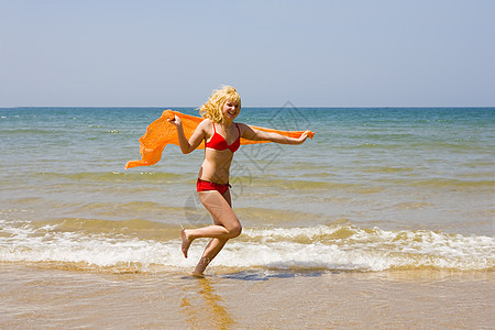 女孩跑在海滩上喜悦女性女士海洋太阳背景图片