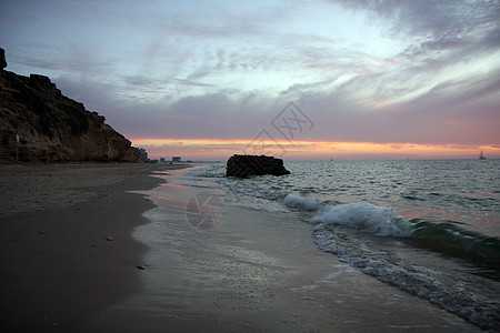 海的红日落海洋海岸阳光石头闲暇旅行波浪假期海滩沙堡图片